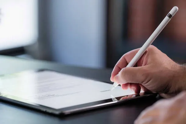 Imagen en donde se ve a una persona firmando un documento electrónico en representación de liberación de un dictamen de gas.