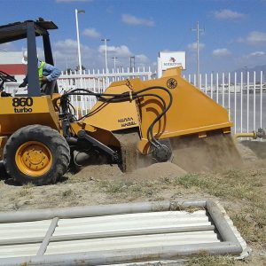 Elemento del personal de MacoGas que se encuentra en medio de trabajo de excavación con maquinaria pesada recogiendo tierra.
